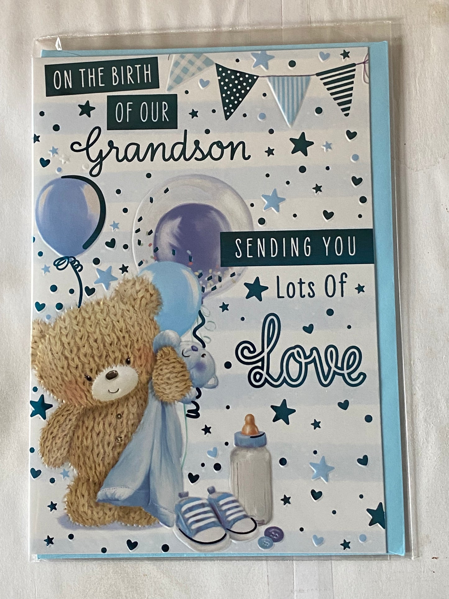 On The Birth of Our Grandson Sending You Lots Of Love New Baby Boy Born Card From The Grandparents Teddy Holding Blue Blanket/Balloons/Bunting/Blue Words Foil Detail(PH48412E)